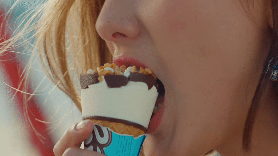 Девушка облизывает мороженое. Девушка с мороженым. Девушка ест мороженное. Девушка кусает мороженное.