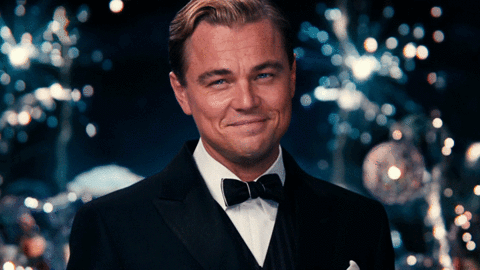 GIF of Leonardo DiCaprio in the movie "The Great Gatsby" raising a glass