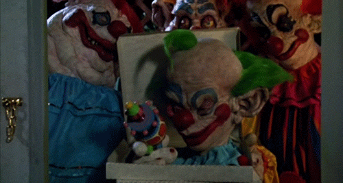 A Killer Klown inflating a balloon animal with a sinister grin, showcasing the film's darkly comedic horror style