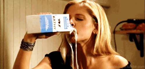 mulher loira bebendo leite direto da caixa