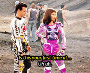 movies,man in driving suit,girl in pink costume,man and woman talking