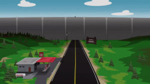cars,road,trees,building,large wall,driving down road